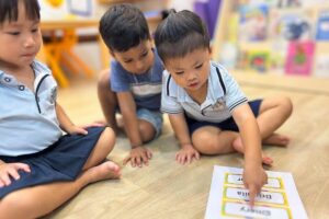 Starshine Montessori Preschool children participating in a name recognition and language activity in a Montessori-style classroom setting.