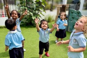 Preschool children at Starshine Montessori joyfully playing outdoors on a sunny day, engaging in bubble play and outdoor learning.
