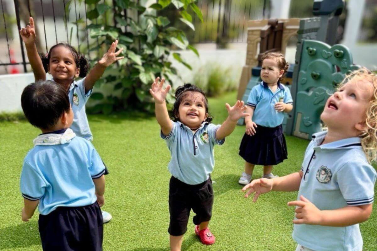 Preschool children at Starshine Montessori joyfully playing outdoors on a sunny day, engaging in bubble play and outdoor learning.